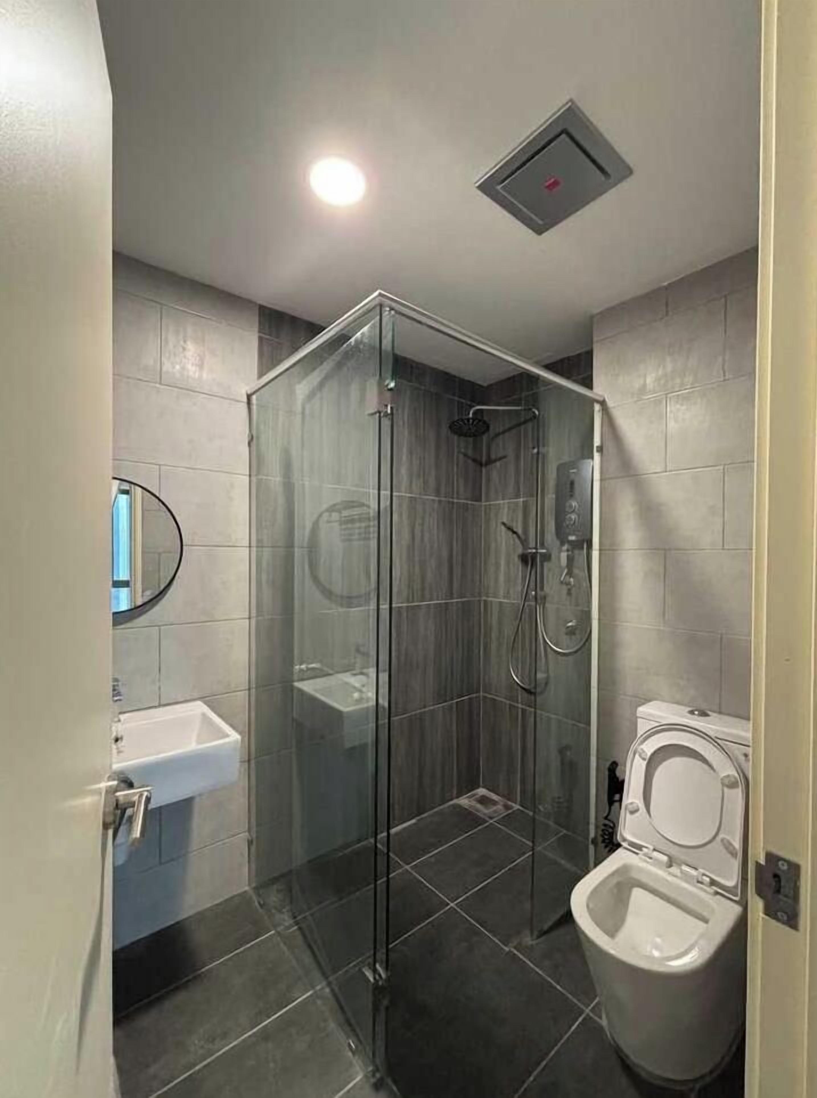 Een badkamer met een douchecabine, een wit wastafelmeubel en een toilet.