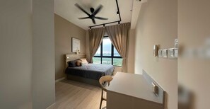 A bedroom with a bed, a desk, a chair, a ceiling fan, and a window with curtains. - OYO O Meta City Residences (Seri Kembangan)