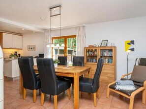 Un coin repas avec une table et des chaises en bois, une bibliothèque et une lampe.