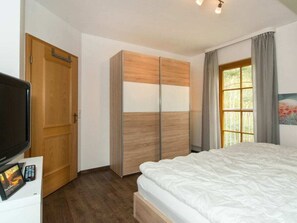 A bedroom with a bed, a wardrobe, a television, and a window with curtains. - 9/t6 Holiday Home Park \"freesenbruch\" (Zingst)