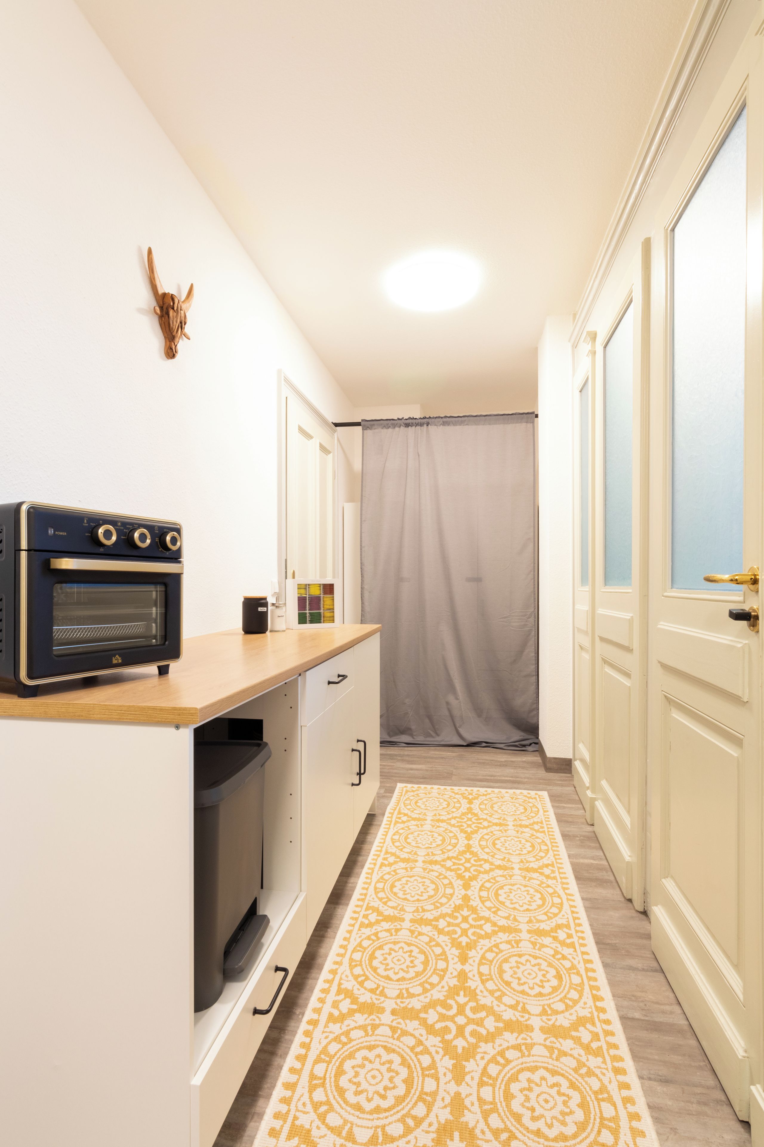 A compact kitchen with a built-in oven, a microwave, and a small refrigerator.