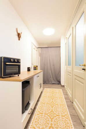 A compact kitchen with a built-in oven, a microwave, and a small refrigerator.