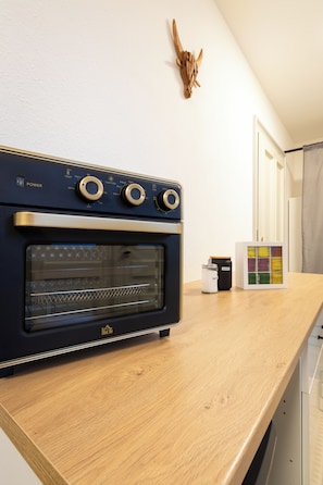 A kitchen with a built-in oven, a wooden countertop, and a wall-mounted decoration.