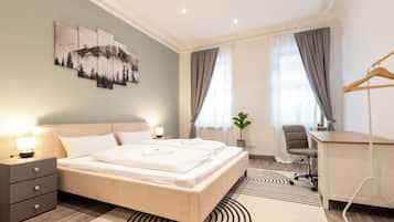 Ein modernes Hotelzimmer mit einem großen Bett, Nachttischen, einem Schreibtisch und einem Stuhl.