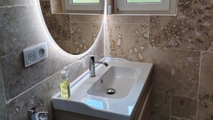 A bathroom with a round mirror, a window, and a sink. - Villa 'Piscine 9pers SaôneBeaujolais' with Private Pool, Shared Terrace and Wi-Fi (Montmerle-sur-Saône)