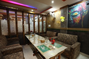 A dining area with a table set for four, surrounded by upholstered chairs.