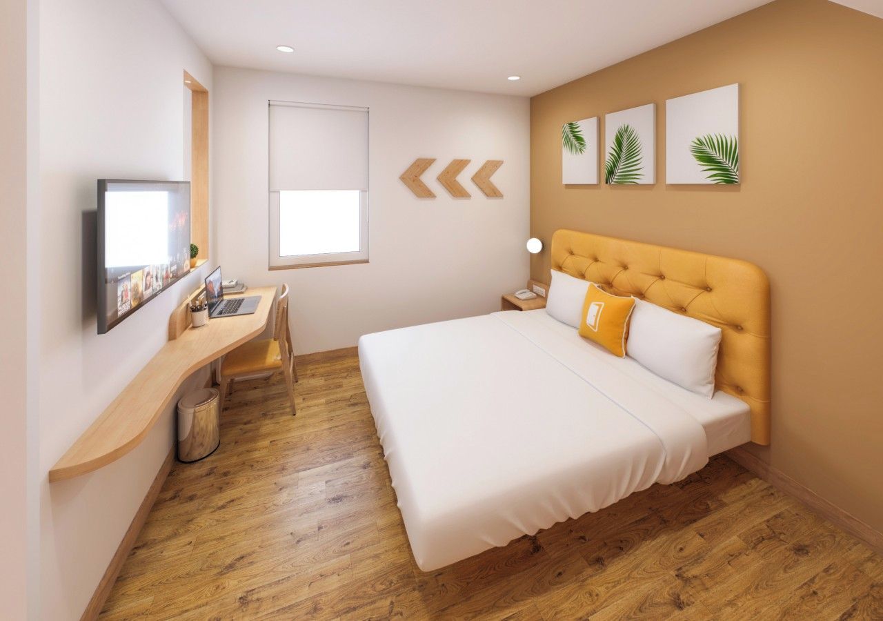 Un dormitorio con una cama, un escritorio y una silla.