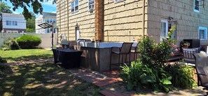 An outdoor patio with a grill, chairs, and a small table. - Spacious 3BR-2BA Upstairs Unit near NYC Train & Bus - Driveway Parking Included (Roselle)