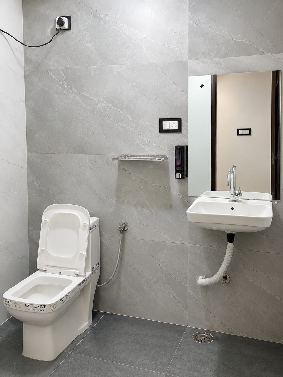 A modern bathroom with a toilet, sink, and mirror.
