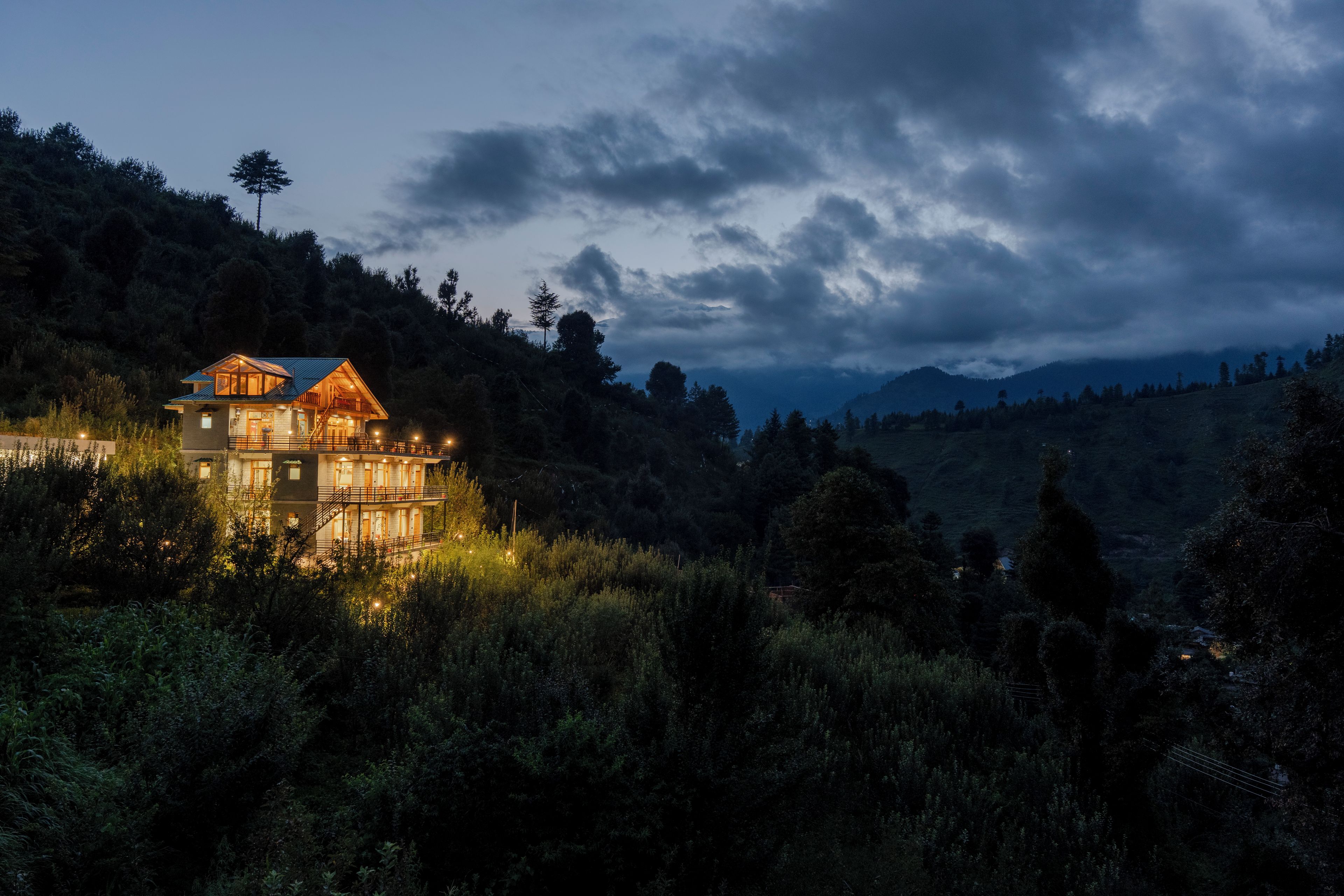 A two-story lodge with a balcony and a mountain view.