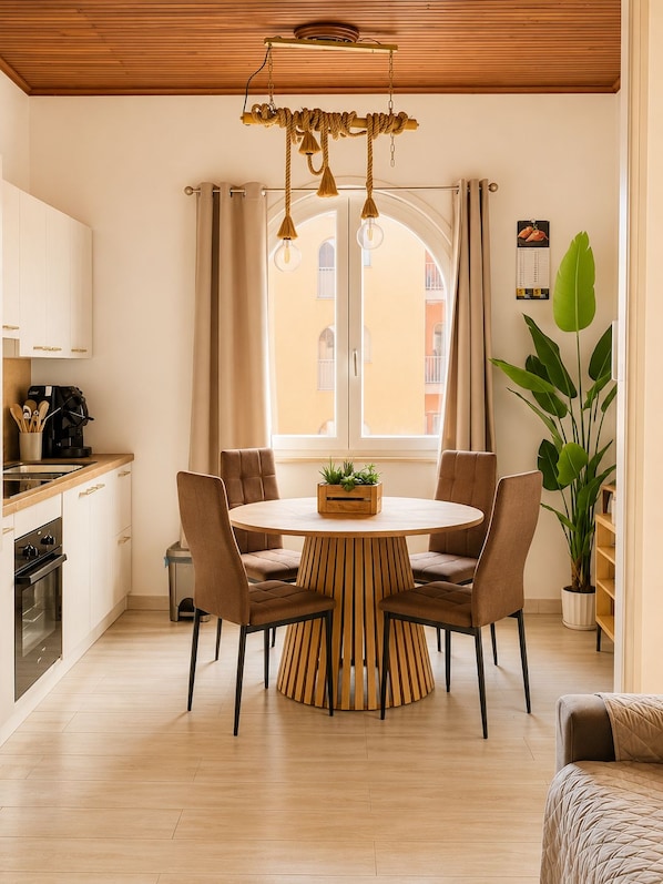 Una cocina moderna con una mesa de comedor redonda, sillas y una planta en maceta.