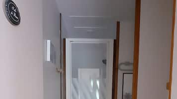Ein Badezimmer mit Toilette, einer Duschkabine und einer Tür mit Milchglas.