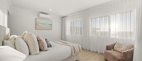 A modern bedroom with a bed, a sofa, and a window with sheer curtains.