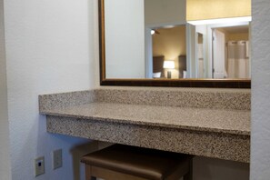 A bathroom with a granite countertop, a mirror, and a bench. - Modern 2B Resort Condo Just 8 Minutes to Disney (Orlando)