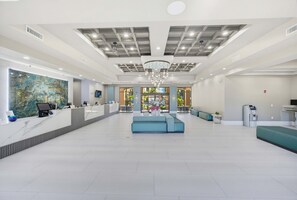 A spacious lobby with a reception desk, seating area, and a view of the outdoors. - Modern 2B Resort Condo Just 8 Minutes to Disney (Orlando)
