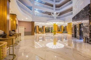A spacious lobby with a central fountain, multiple floors, and a modern design. - Mira Meridia Beach Resort Hotel (Alanya)