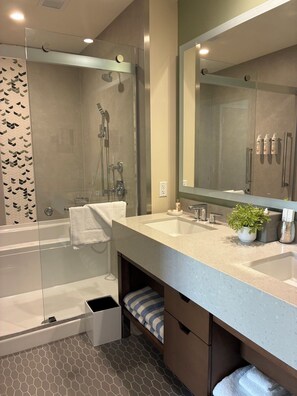A modern bathroom with a glass-enclosed shower, a large mirror, and a vanity with a sink and storage. - Newly Built & Fully Equipped | Enjoy a Waikiki Stay for Up to 6 People (Honolulu)