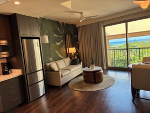 A modern hotel room with a kitchenette, a sofa, a round coffee table, and a balcony with a view. - Newly Built & Fully Equipped | Enjoy a Waikiki Stay for Up to 6 People (Honolulu)