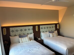 A hotel room with two beds, a ceiling fan, and a patterned headboard. - Newly Built & Fully Equipped | Enjoy a Waikiki Stay for Up to 6 People (Honolulu)