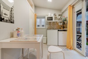 A compact kitchen with a microwave, coffee maker, and a small refrigerator. - Holiday Home 'Estudio Minimalista En Galizano' with Private Terrace, Private Garden and Wi-Fi (Cantabria)