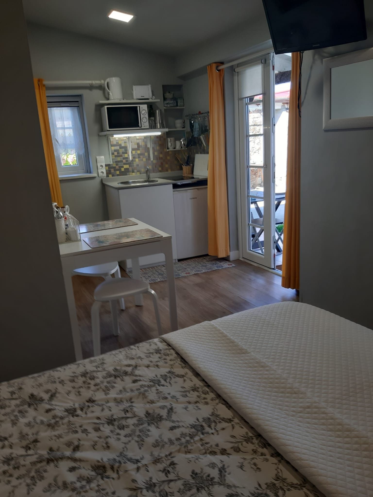 Une pièce de taille modeste comprenant un lit, une petite kitchenette et un coin repas.