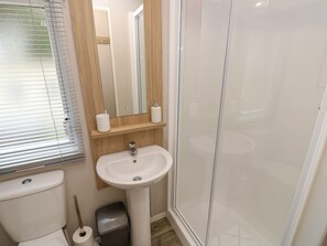 A bathroom with a toilet, sink, and shower. - Serenity Thorness Bay (Cowes)