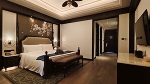 Une chambre d’hôtel avec un lit, une table de chevet, une lampe et un grand miroir.