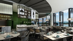 Un restaurant offrant une vue sur un plan d’eau, doté d’un sol en marbre et d’un mobilier moderne.