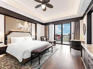 A spacious bedroom with a large bed, a desk, and a balcony. - Wanda Vista Guangzhou (Guangzhou)