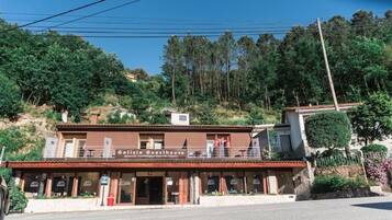Un edificio de dos pisos con un balcón en el nivel superior, identificado como 'Galicia Guesthouse'.