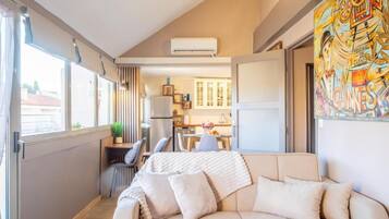Un espacio habitable compacto con sofá, comedor y cocina.