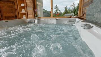 Ein Whirlpool mit Blick auf eine gebirgige Landschaft durch ein Fenster.