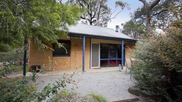 A single-story building with a flat roof, a front door, and a small porch area.