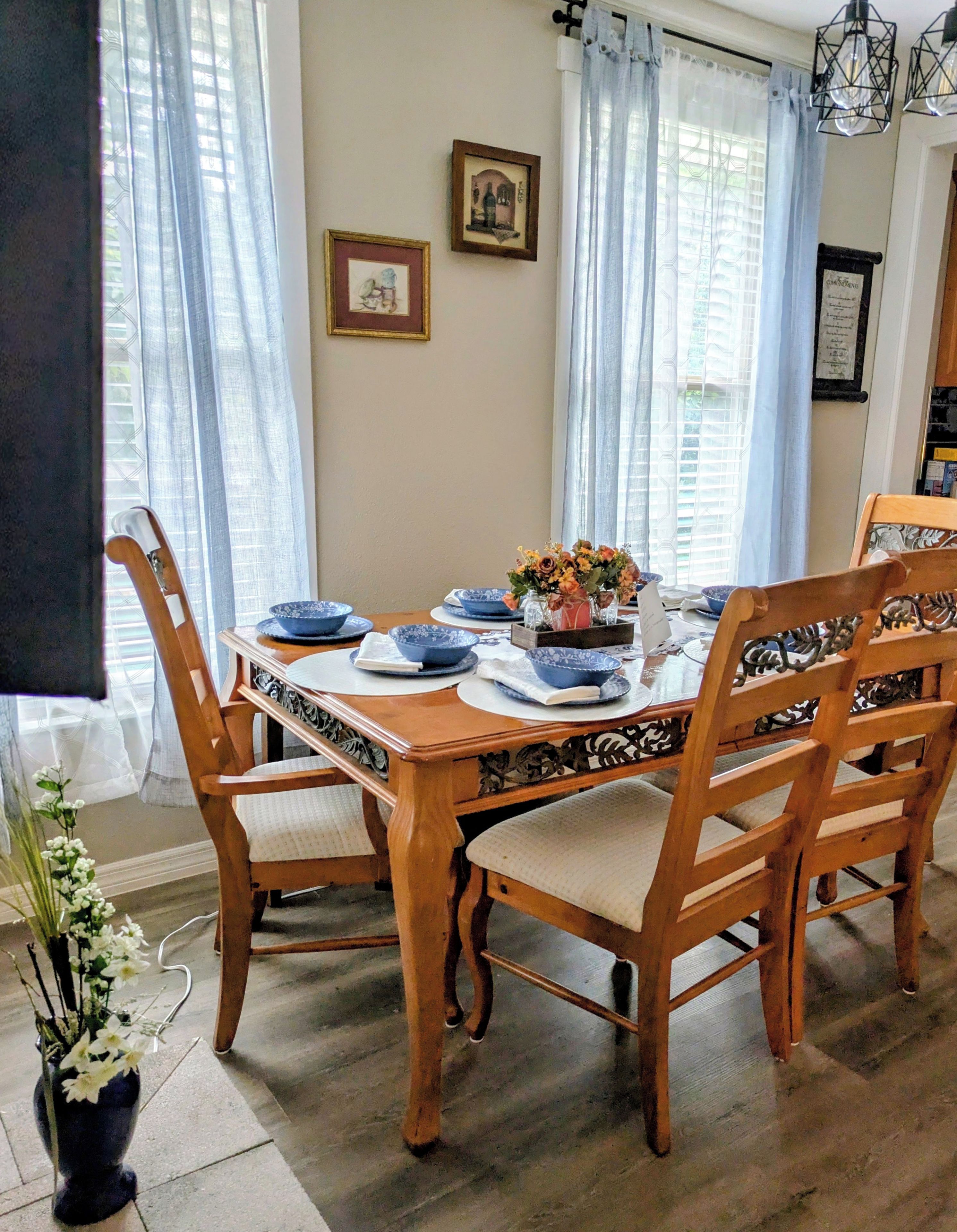 Comedor con una mesa de madera dispuesta para seis personas, rodeada de sillas con asientos acolchados.