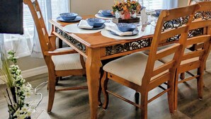 A dining room with a wooden table set for six, surrounded by chairs with cushioned seats. - 3-bedroom bungalow in Clermont ,25 miles to Disney (Clermont)