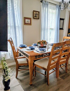 Comedor con una mesa de madera dispuesta para seis personas, rodeada de sillas con asientos acolchados.