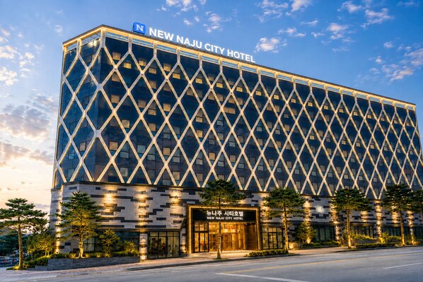 A modern hotel building with a distinctive diamond-patterned facade and a prominent entrance.