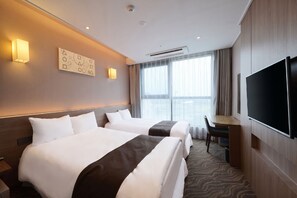 A hotel room with two beds, a desk, a chair, a flat-screen TV, and a large window with curtains.