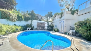 Una piscina amb aigua cristal·lina blava, envoltada per un solàrium de formigó i una paret blanca on es pot veure parcialment el text 'TERRASOL'.