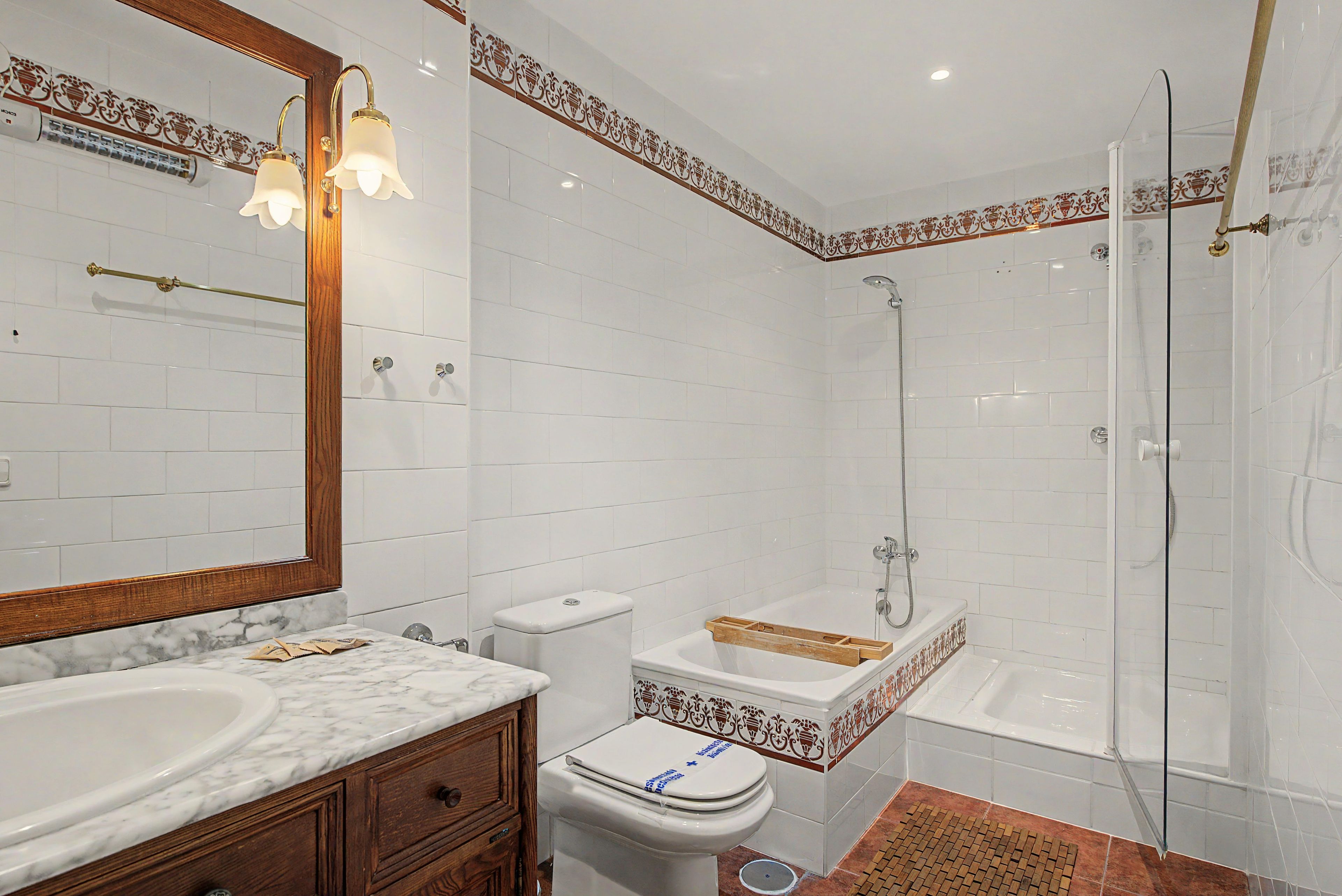 Ein Badezimmer mit Marmorwaschtisch, Toilette, Dusche und Badewanne.