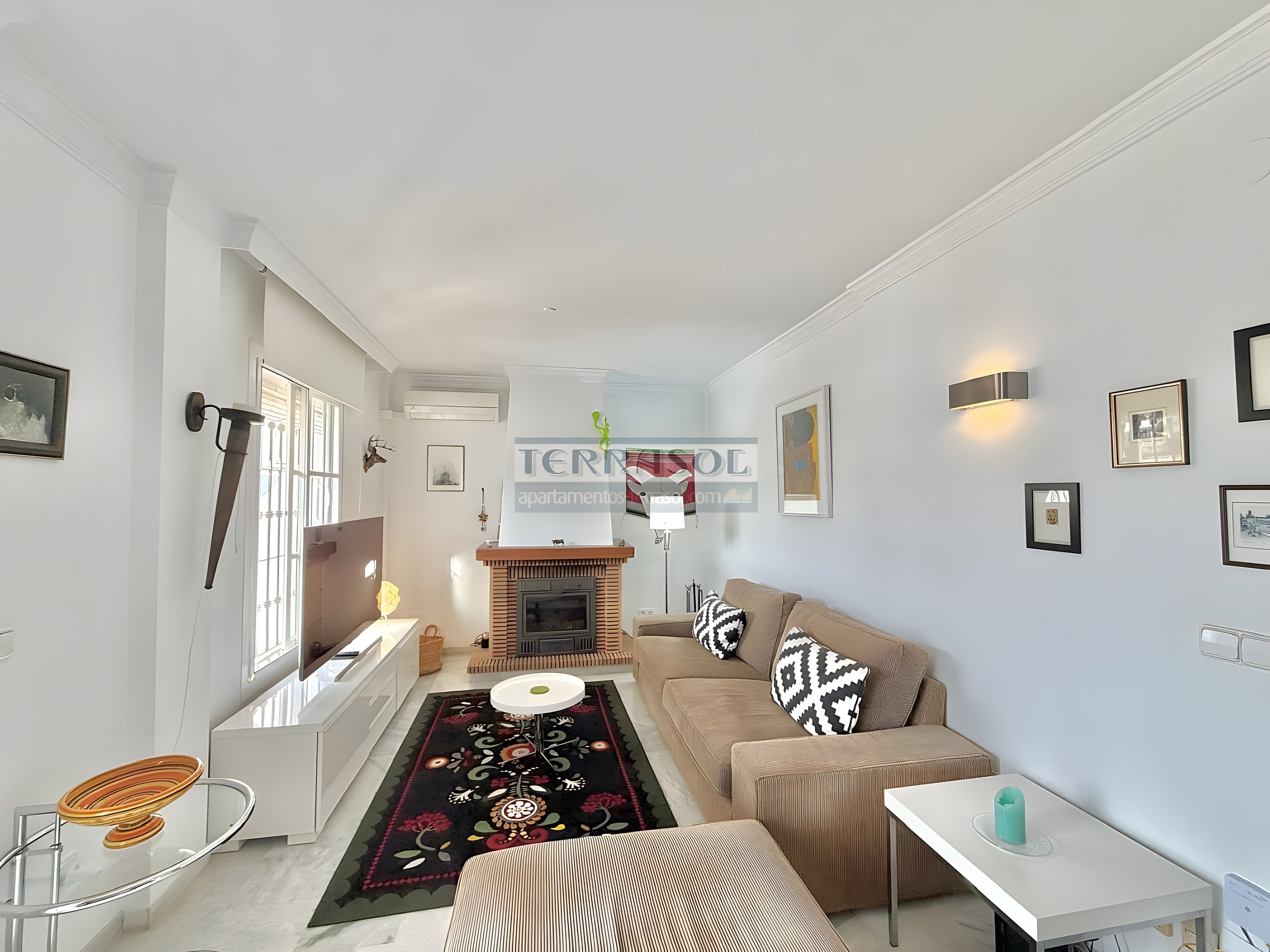 En moderne stue med sofa, sofabord og pejs.
