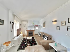 En moderne stue med sofa, sofabord og pejs.