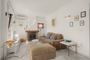En stue med pejs, sofa, sofabord og TV-møbel.