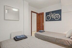 A bedroom with a bed, a radiator, a door, a mirror, and a wall-mounted bicycle illustration.