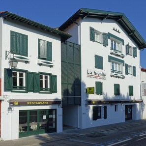 En bygning med to etager, hvor der er restaurant i stueplan og hotel på øverste etage.