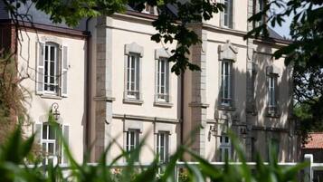 A multi-story building with a classical architectural style, featuring symmetrical windows and a central entrance.