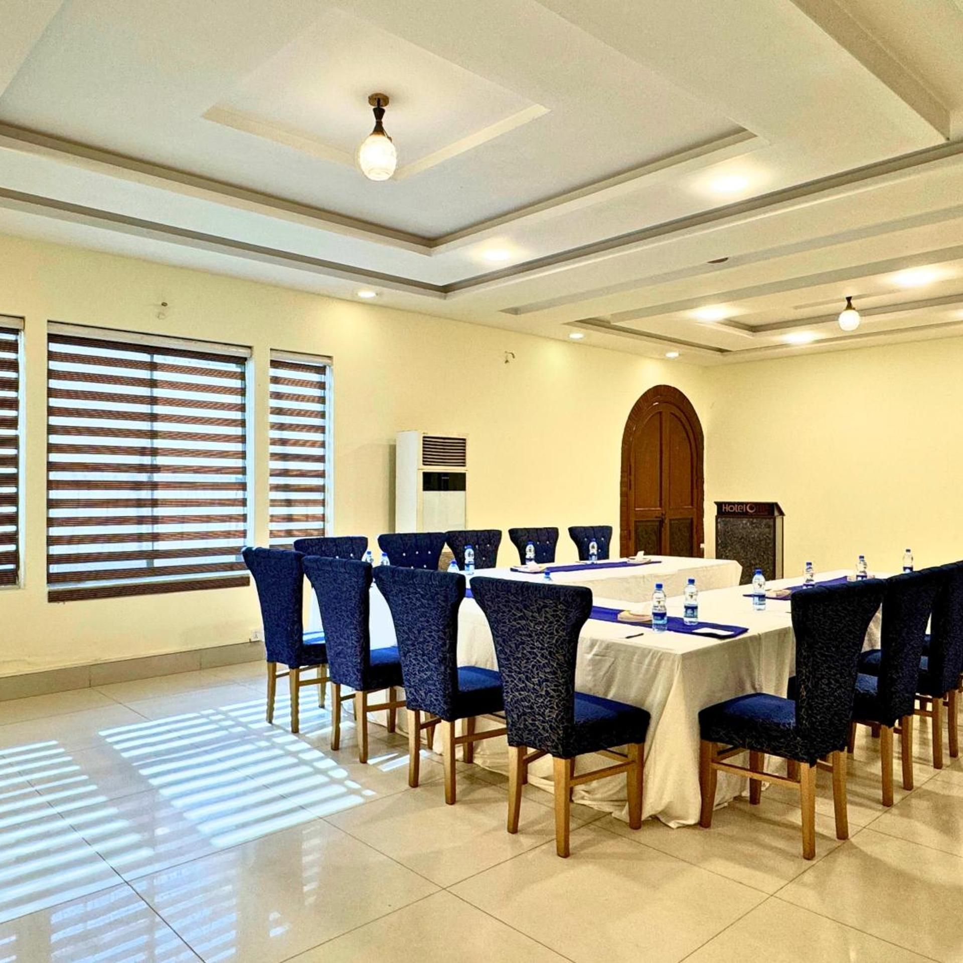 A conference room with a long table, chairs, and a large arched doorway.