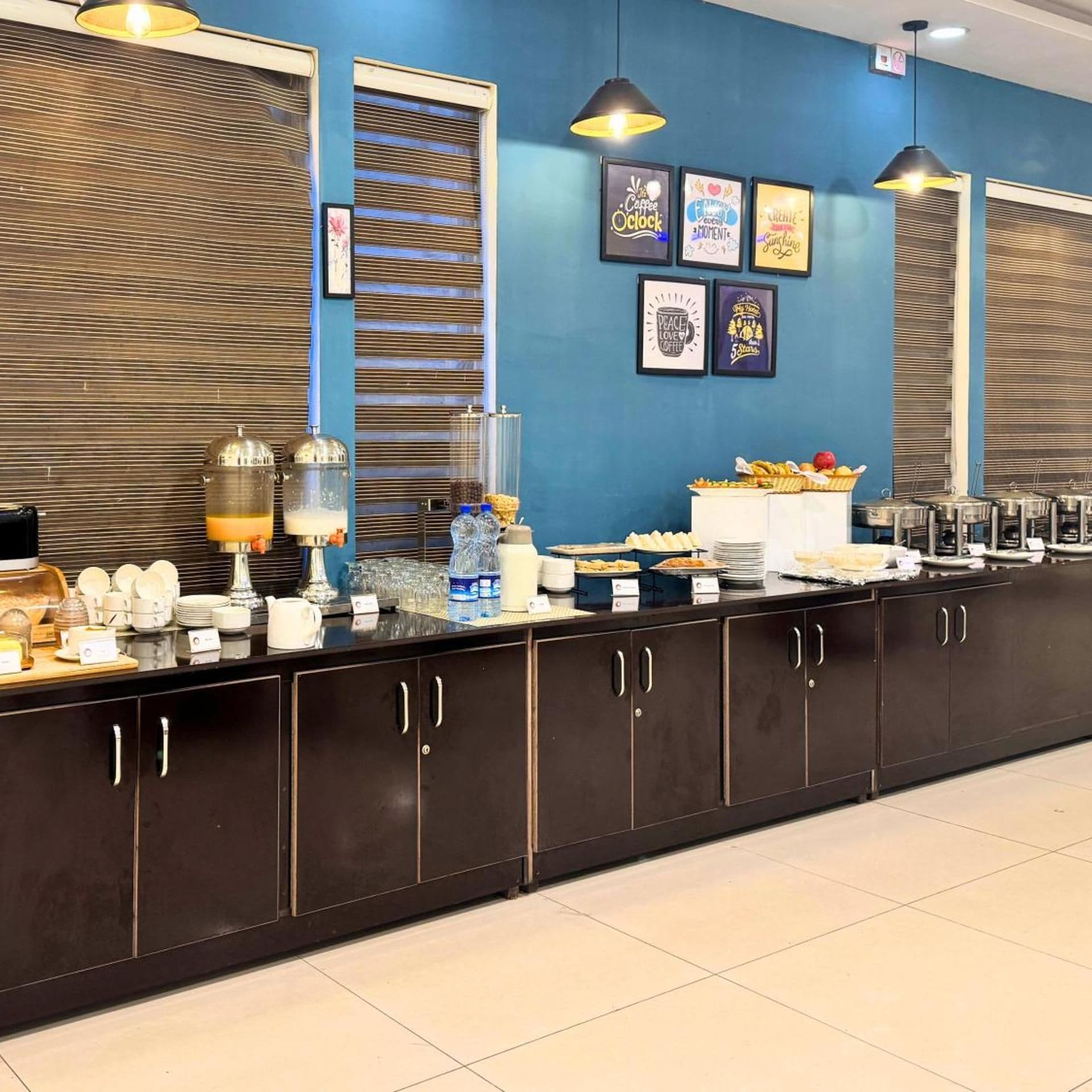 Een ontbijtbalk met een koffieapparaat, waterdispensers en diverse soorten eten.