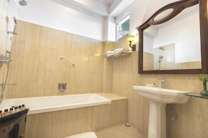 Une salle de bain avec une baignoire, un lavabo et une douche.