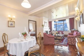 Une pièce comprenant une table à manger dressée pour quatre personnes, un canapé et une cheminée.